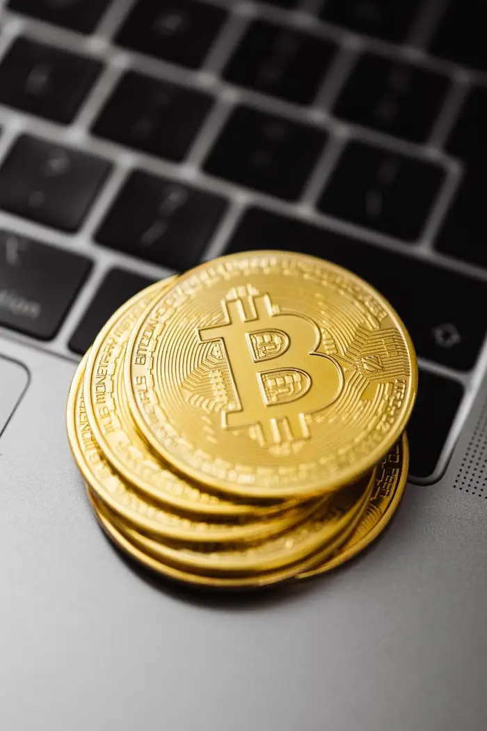 Close-up of physical Bitcoin coins stacked on a laptop keyboard, symbolizing modern cryptocurrency and technology.